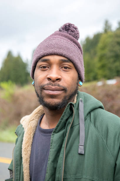 Serious afro caribbean man looking at the camera wearing a toque and a parka